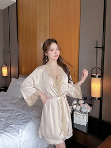 Detail of elegant champagne satin sleepwear with intricate lace trim on sleeves and hem