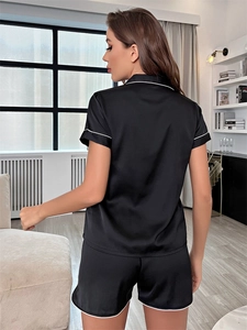 Vue arrière d'un pyjama en soie noire avec liseré blanc sur les manches et l'ourlet