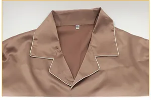 Close-up of champagne brown satin pajama collar with white piping and XL size tag