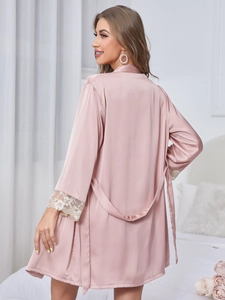 Detail of pink satin sleepwear showing delicate lace cuffs and smooth silk-like texture