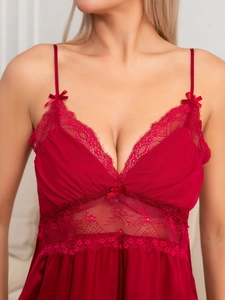 Détail de la dentelle rouge et du satin de soie sur la nuisette avec col en V et nœuds
