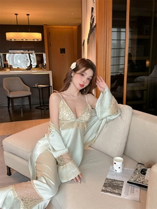 Close-up of mint green satin sleepwear with delicate lace trim on the robe and gown