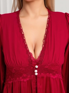 Détail de la nuisette rouge en satin montrant le col en V et les boutons décoratifs