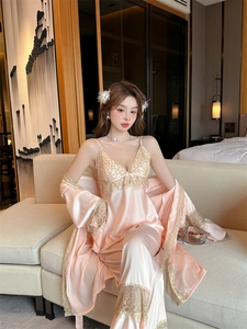 Detailed close-up of pink silk pajamas with gold lace trim and soft fabric texture