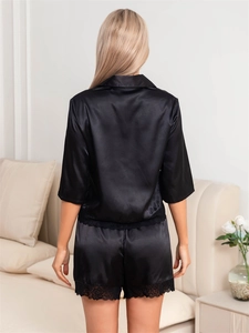 Rear view of black satin pajama set featuring delicate lace trim on hem and shorts