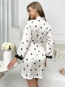 Détail du peignoir en soie glacée blanche avec motifs de cœurs et poignets en dentelle