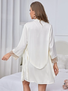 Detail of white satin robe featuring elegant lace cuffs and a silky waist tie closure
