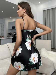 Détail de la nuisette en satin noir avec imprimé floral et fines bretelles spaghetti