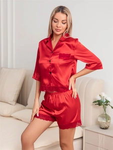 Detail of red satin pajamas with delicate lace trim on the sleeves and shorts