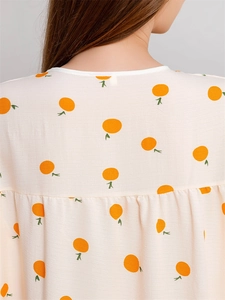 Detail of seersucker summer nightgown with orange prints and round neckline on back