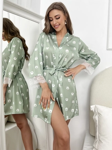 Détail du peignoir en satin vert clair avec imprimé floral et poignets en dentelle blanche