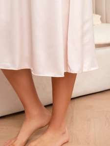 Vue détaillée de l'ourlet en satin rose montrant la texture soyeuse et les coutures