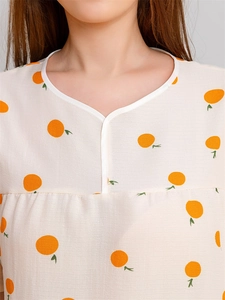 Detail of seersucker summer nightgown with orange fruit print and V-neckline texture