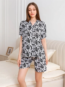 Detail of floral rayon pajamas set featuring short-sleeve top and matching shorts in a bedroom