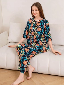 Detail of floral rayon pajamas showing navy blue fabric with orange and yellow prints