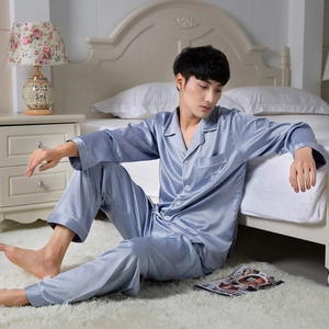 Men's light blue satin pajamas set with long sleeves and classic lapel in bedroom setting