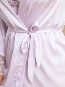 Detail of lavender satin robe showing smooth fabric texture and delicate lace trim