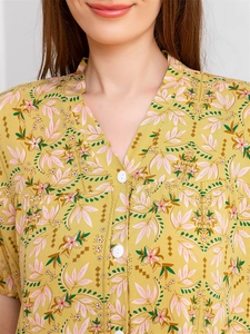 Detail of V-neck button closure on yellow floral rayon pajama top with soft texture
