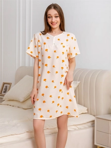 Detail of summer seersucker nightdress featuring small orange prints and crew neckline