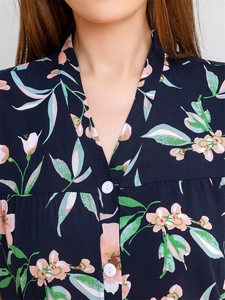 Détail du haut de pyjama bleu marine à fleurs avec col en V et boutons blancs