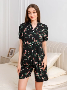 Detail of V-neck button-down pajama top with red rose floral print on black fabric