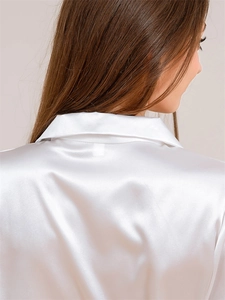 Detail of white satin pajamas showing the silky texture and elegant collar craftsmanship