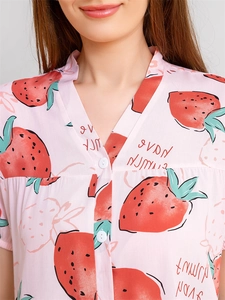 Détail d'un haut de pyjama rose à col en V avec imprimé fraises et texte HAVE FUN