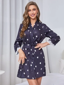 Détail du peignoir en soie bleu foncé avec poignets en dentelle et motifs de coeurs
