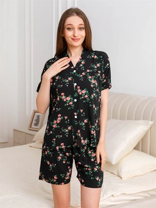 Detail of V-neck rayon pajama set featuring pink rose floral print on black background
