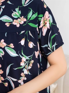 Détail d'un haut de pyjama fleuri avec poignets élastiques à volants en bleu marine