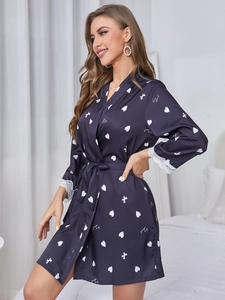 Détail de peignoir en soie bleu marine avec poignets en dentelle et motif de cœur
