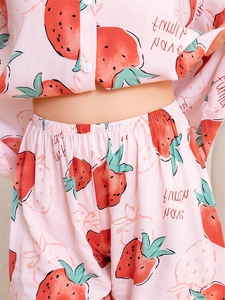 Gros plan sur l'imprimé fraises du pyjama rose avec taille élastique et boutons blancs