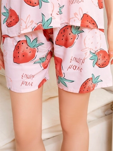 Détail du short de pyjama en coton rose avec motifs de fraises et texte imprimé