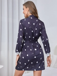Détail du peignoir en soie bleu marine avec motifs de cœur et poignets en dentelle fine