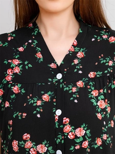 Detail of V-neck floral pajama top with white buttons and red flower print on black fabric