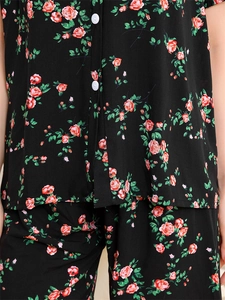 Close-up of black floral rayon pajama set featuring red rose prints and white buttons