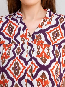 Detail view of V-neckline with white buttons and geometric diamond print on rayon pajama top