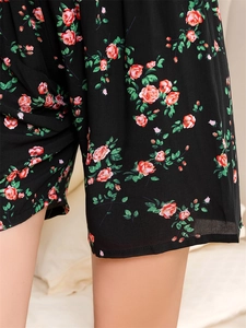 Close-up of floral print pajamas featuring red rose patterns on breathable black fabric