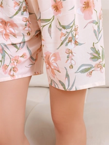 Dettaglio ravvicinato dei pantaloncini del pigiama rosa con stampa floreale di gigli