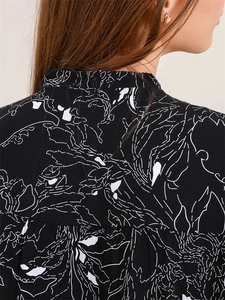 Détail du tissu à imprimé floral noir et blanc élégant avec plis au col dos