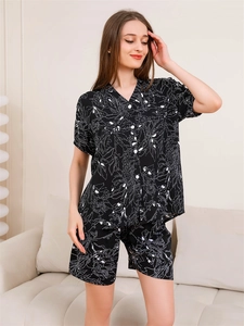 Gros plan du pyjama noir à col en V avec des motifs floraux blancs sous une lumière douce