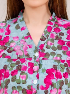 Detail of V-neck neckline with buttons and rose pink leaf print on viscose pajama top