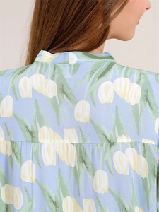 Detail of tulip floral print on light blue cotton pajamas showing fabric texture and seams