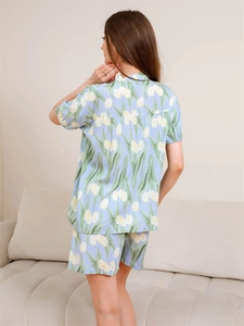 Rear view of light blue women pajama set with yellow tulip print in a home setting