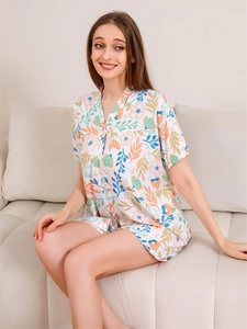 Close-up of lightweight summer pajama set with vibrant tropical floral and leaf prints
