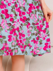 Detail of floral print on light blue summer dress with pink leaves and clean hem