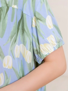 Detail of light blue pajama top sleeve with yellow tulip print and elastic cuff texture