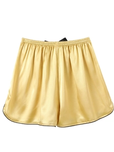 Detail of champagne gold silk satin sleep shorts with black hem and elastic waist