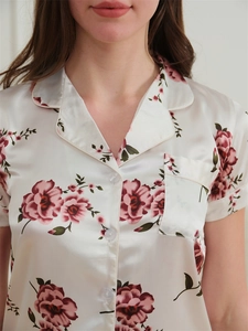 Détail du haut de pyjama en soie glacée avec imprimé floral rose rouge et col à revers