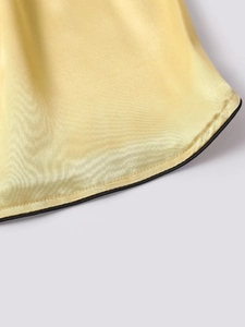 Detailed close-up of ice silk satin fabric with black piping and high-quality stitching